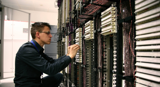 Un technicien Jiliti connecte des câbles réseau dans un datacenter sécurisé