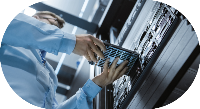 Technicien remplaçant un disque dur dans une baie de serveurs informatiques